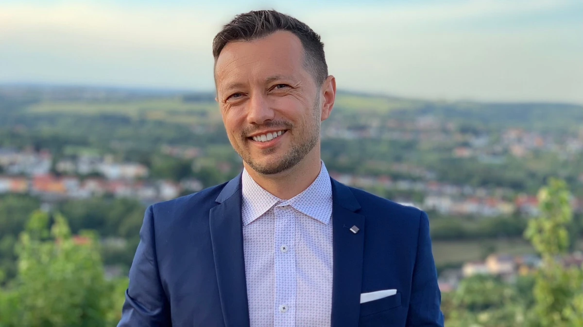 A man in a shirt and jacket outside and up high