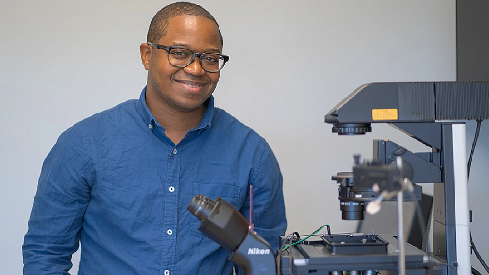 A man sitting next to a machine and smiling 