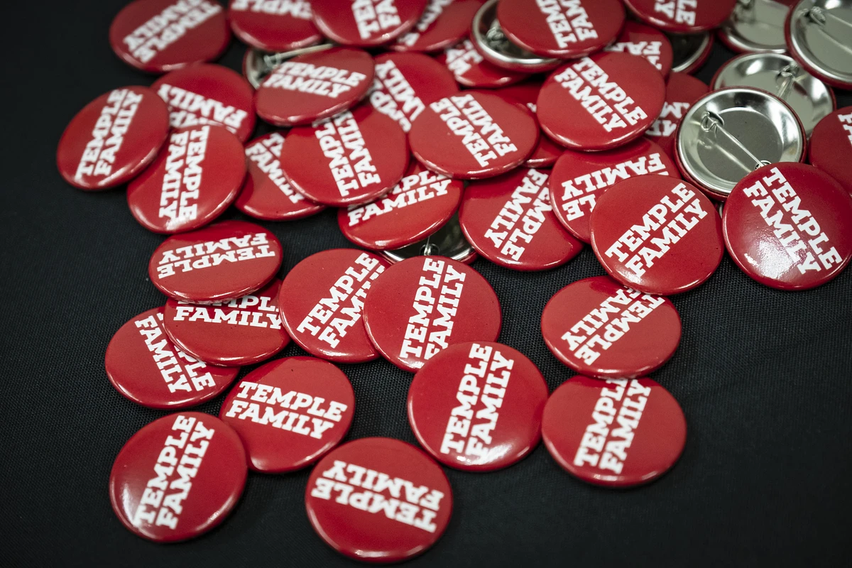 A collection of red buttons with "TEMPLE FAMILY" printed in white.
